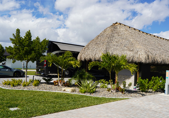 Class A motorcoach site with tiki hut and tropical landscaping at Laguna Caribe in Fort Myers.
